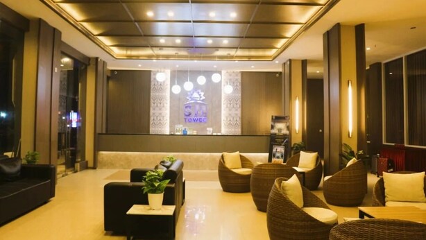 A modern hotel lobby with a reception desk, seating area, and decorative lighting. - SM Tower Hotel & Convention Center Berau (Tanjung Redeb)