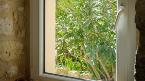 A window with a view of green plants outside. - Chez mamie (Montdragon)