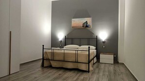 Une chambre à coucher avec un lit, des tables de chevet et un tableau au mur.