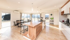 Una cocina moderna con una isla central, ventanas amplias y un comedor con vistas.