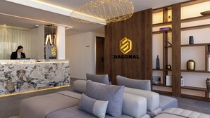 Una moderna recepción con mostrador de mármol, una recepcionista y el logotipo de 'DIAGONAL'.