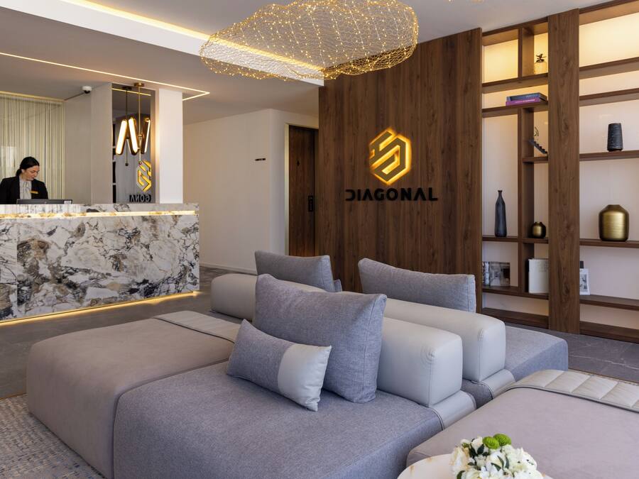 Una moderna recepción con mostrador de mármol, una recepcionista y el logotipo de 'DIAGONAL'.