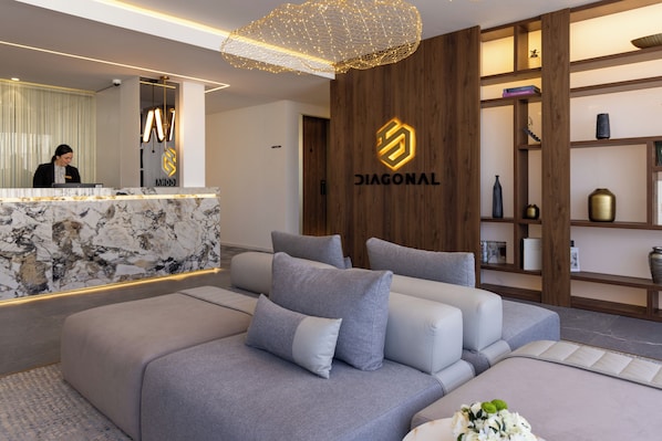A modern reception area with a marble counter, a receptionist, and a logo for 'DIAGONAL'.