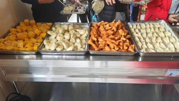Ein Buffet mit vier Speisen: Mais, Knödel, frittierte Speisen und eine weitere Knödelvariante.