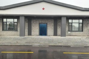 A building with a red star on the roof, a blue door, and a brick facade. - Holiday Inn Wulagai Management Area (East Ujimqin Banner)