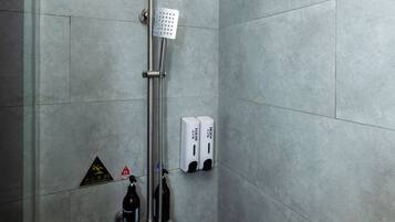A modern shower with a square showerhead and a handheld shower attachment.