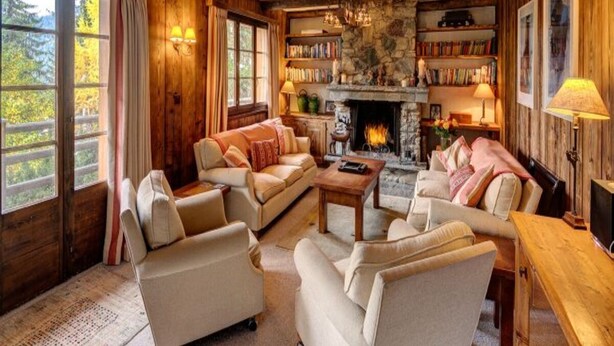 Una sala de estar acogedora con chimenea, estanterías y asientos cómodos.