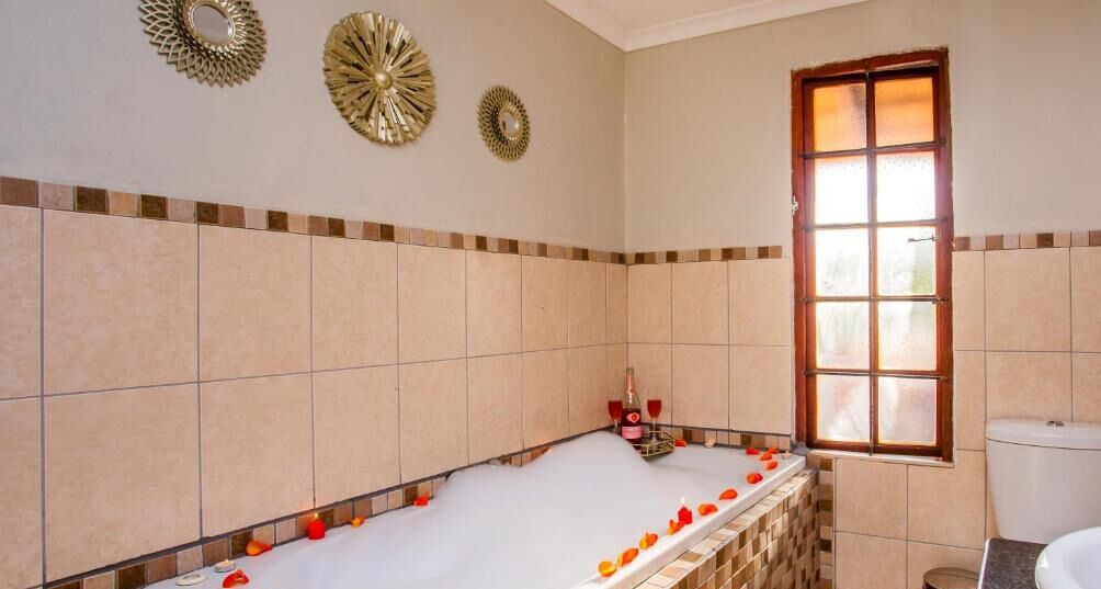A bathroom with a bathtub, a toilet, and a window.