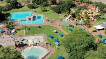 Ein Luftbild eines Themenparks mit mehreren Schwimmbecken, Wasserrutschen und Campingplätzen.