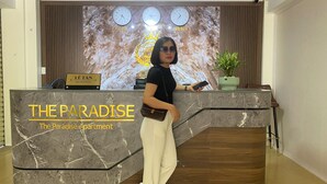 Una recepción con diseño de mármol, un reloj y un cartel que indica 'Lê Tân Reception'.