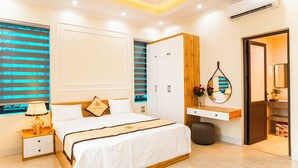 Un dormitorio moderno con una cama grande, un armario, una tocador con espejo y una ventana con persianas.