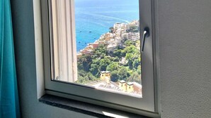 A window with a view of a coastal town and the sea. - Casa FeFe a scenic view of Positano and a swimming pool! (Positano)