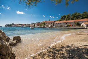 A coastal town with clear waters, a pebbly beach, and stone buildings with red roofs. - Fancy Apartments Dream (Smokvica)