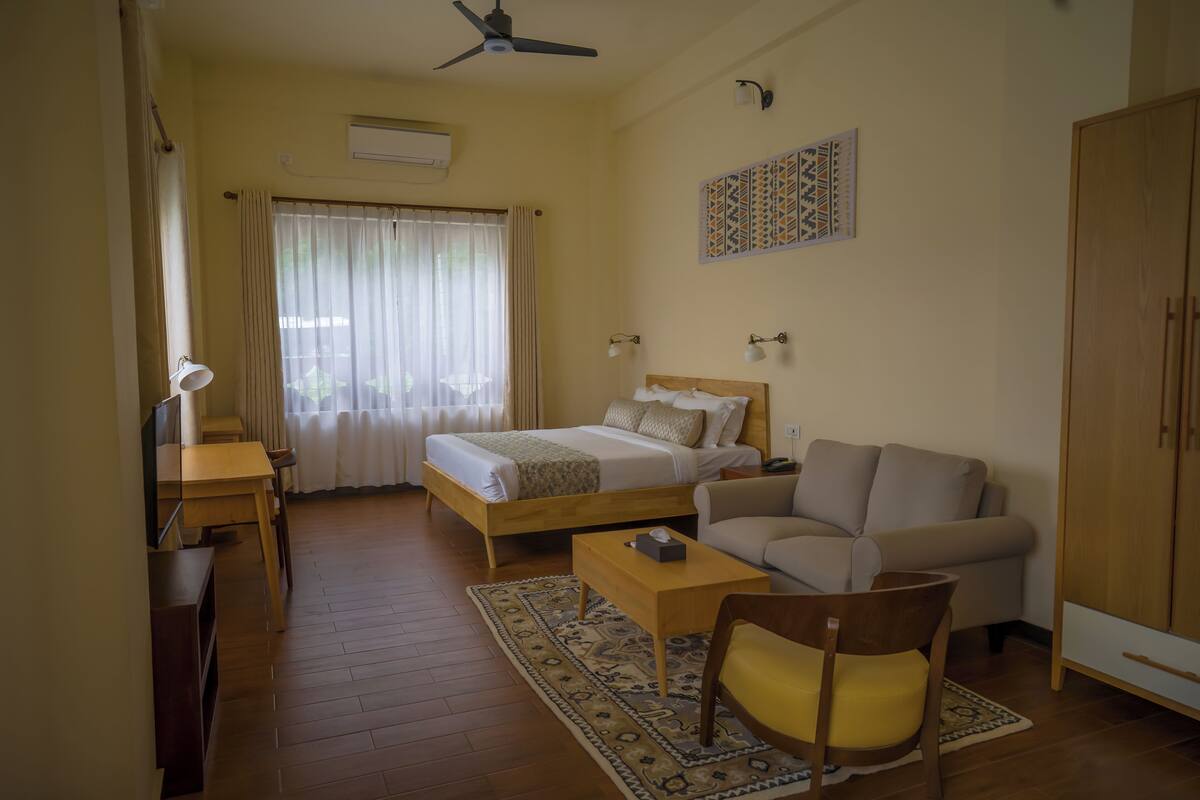 Une chambre à coucher avec un lit, un canapé, un bureau et une chaise.