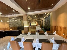 Un comedor con una mesa larga dispuesta para una comida, paneles de madera en las paredes y una pared de acento de piedra.