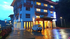 A multi-story building with traditional architectural features, including ornate windows and a balcony. - Legphel Hotel (Phuntsholing)