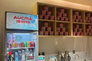 Una máquina expendedora con diversas bebidas y un estante lleno de recipientes rojos.