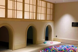 Una habitación con un ventanal grande, una piscina de bolas y una recepción.