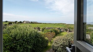 A view of a rural landscape with stone ruins and a stone house. - Cosy Rural Garden Cottage Sea Views Near St Ives (Cornwall)
