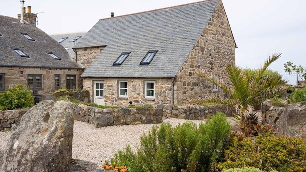A stone building with a sloped roof and multiple windows. - Cosy Rural Garden Cottage Sea Views Near St Ives (Cornwall)