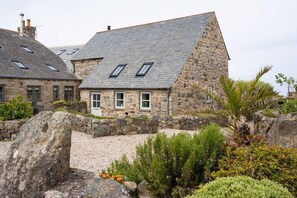 A stone building with a sloped roof and multiple windows. - Cosy Rural Garden Cottage Sea Views Near St Ives (Cornwall)