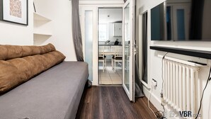 A bedroom with a bed, a TV, and a radiator. - The Tachbrook at No. 195: 6-Bed Historic Townhouse | Victoria (London)