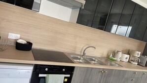 A modern kitchen with a dishwasher, oven, and a sink with a faucet. - 4 Bedroom Apartment in Camblain-ChÃ¢telain (Camblain-Châtelain)