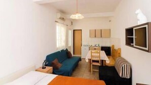 A compact living space with a kitchenette, a dining area, and a sofa. - Apartments Felix Mljet (Mljet)