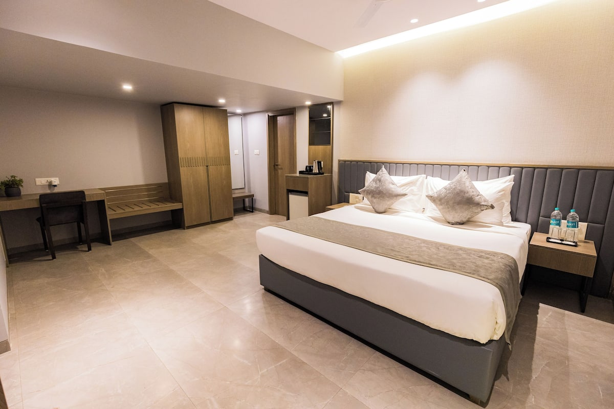 Una habitación de hotel moderna con una cama grande, un escritorio y un armario.