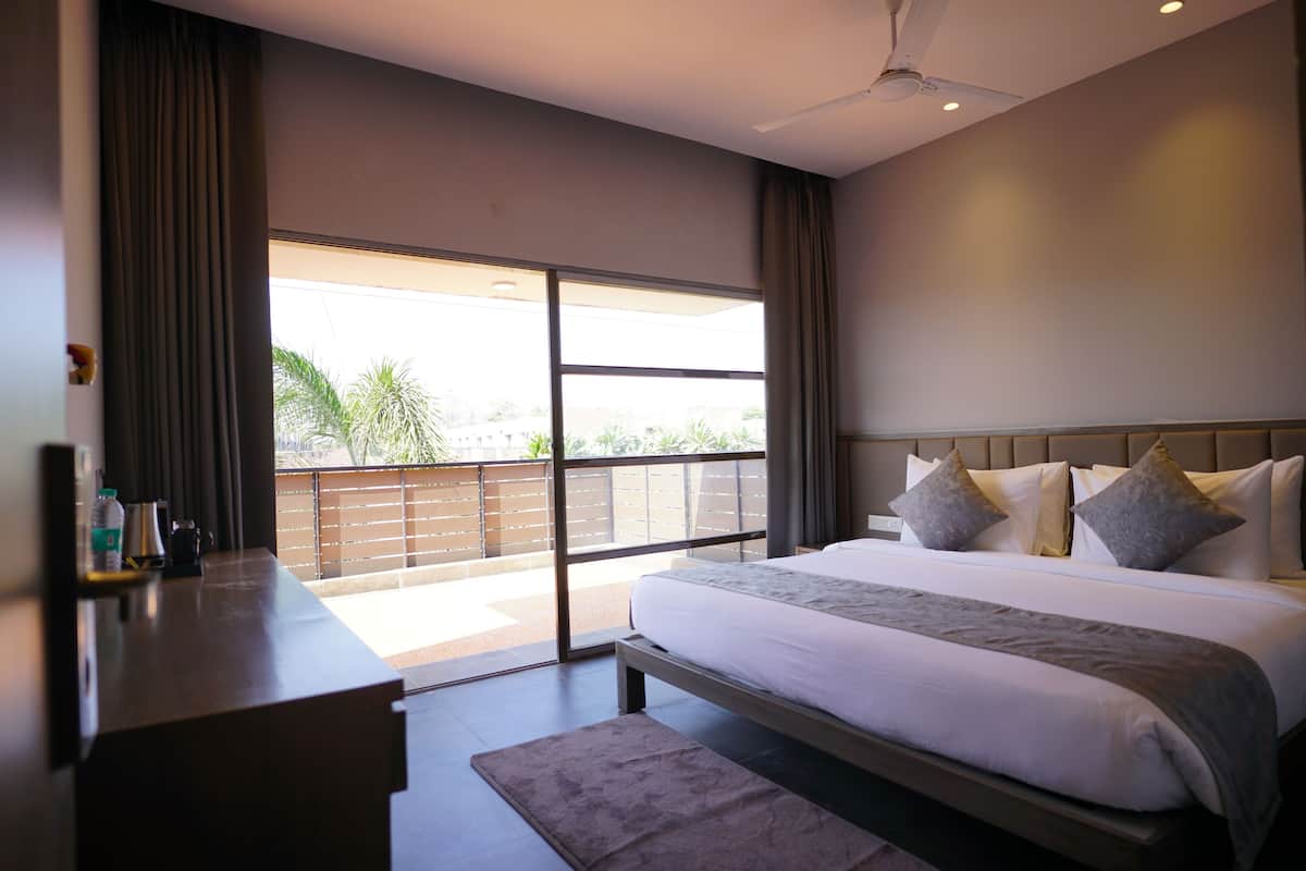 Una habitación de hotel moderna con una cama grande, un escritorio y vistas al exterior.