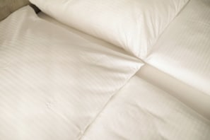 A close-up of a bed with white bedding. - Skyline Hotel  (Hannover)