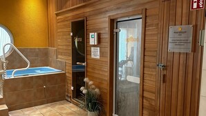 Ein Saunaraum mit Glastür, Bedienfeld und einem Schild, das Sauna ausweist.