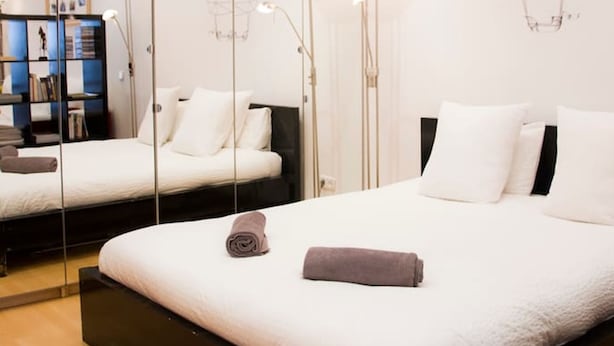A modern hotel room with a large bed, a bedside table, a mirror, and a bookshelf. - Super Studio IN THE Heart OF Trendy Gracia By Myrentalhost (Barcelona)