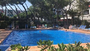 A swimming pool surrounded by trees and buildings.