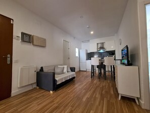 A modern apartment with a living room, kitchenette, and a dining area. - Walk to Camp NOU - Wi-fi AC 3 Bed by Myrentalhost (L'Hospitalet de Llobregat)