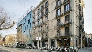 A multi-story building with a row of parked scooters in front. - Modern Penthouse With Views Near Paseo De Gracia By Myrentalhost (Barcelona)