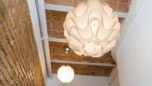 Un plafond orné d’un luminaire sculptural original et un mur décoré d’une tête de taureau.