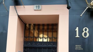 Un portail en métal noir surmonté du chiffre « 18 », et sur lequel on peut lire, à droite, les mots « DESIGN ARANEA BUILDING ».