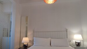 A hotel room with a large bed, two bedside lamps, a decorative ceiling light, and a checkered floor. - Catalan Comfort Near Sagrada Familia (Barcelona)