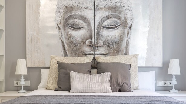 Ein Schlafzimmer mit einem großen Bett, zwei Nachttischen, einer Wand-Klimaanlage und einem großen Kunstwerk über dem Bett.