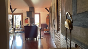 A spacious lobby with a wooden floor, a reception desk, and a large wall-mounted sculpture. - Luminous Designer Loft Style Apt Eixample Views By Myrentalhost (Barcelona)
