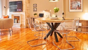 A modern dining area with a wooden table, clear chairs, a black pendant light, and a fireplace. - Love Local Life Near Sagrada Familia By Myrentalhost (Barcelona)