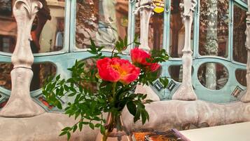 A vase with flowers and a book titled "Spain" on a windowsill.