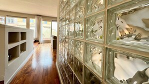 A hallway with a glass wall displaying various sculptures. - Barcelona Gem Penthouse By Myrentalhost (Barcelona)