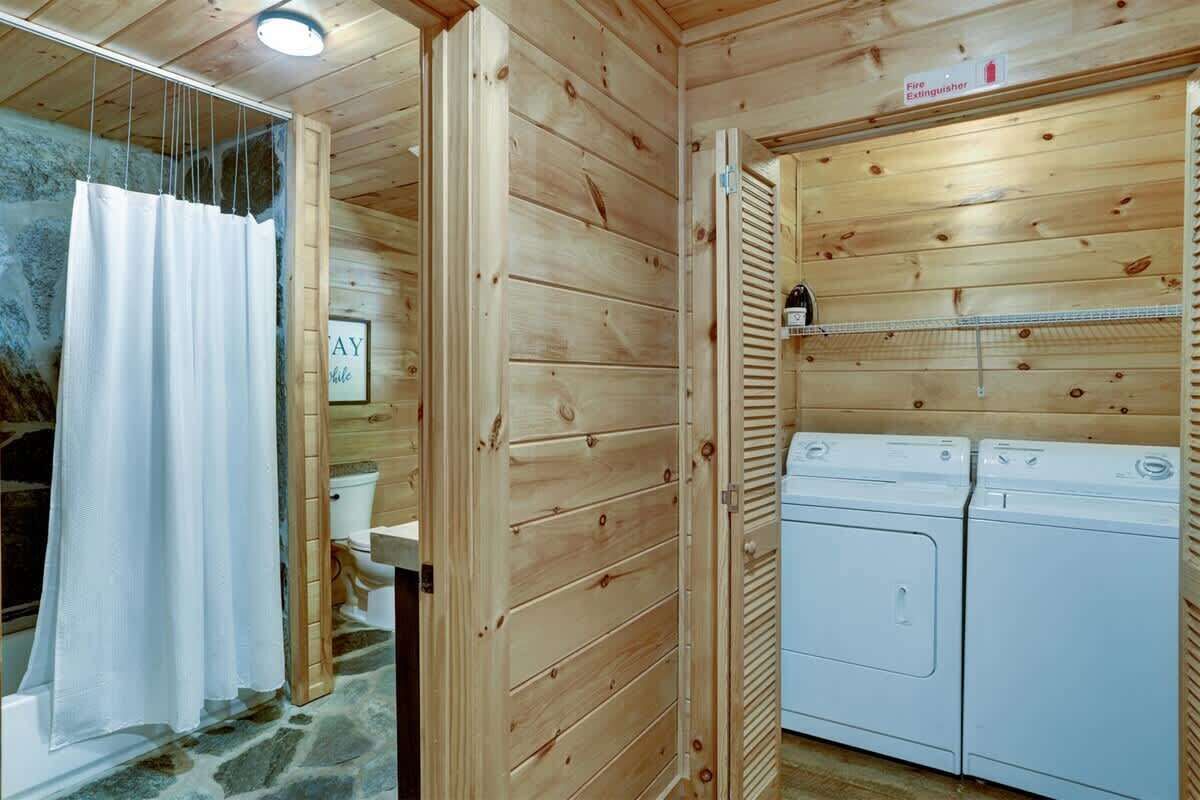 Interno di una baita in legno con doccia, WC e due lavatrici.