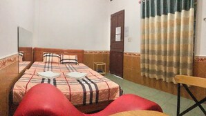 A room with two beds, a wooden chair, and a small table. - Happy Motel (Bien Hoa)