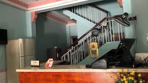 A reception desk with a clock, a fan, and a computer. - Happy Motel (Bien Hoa)