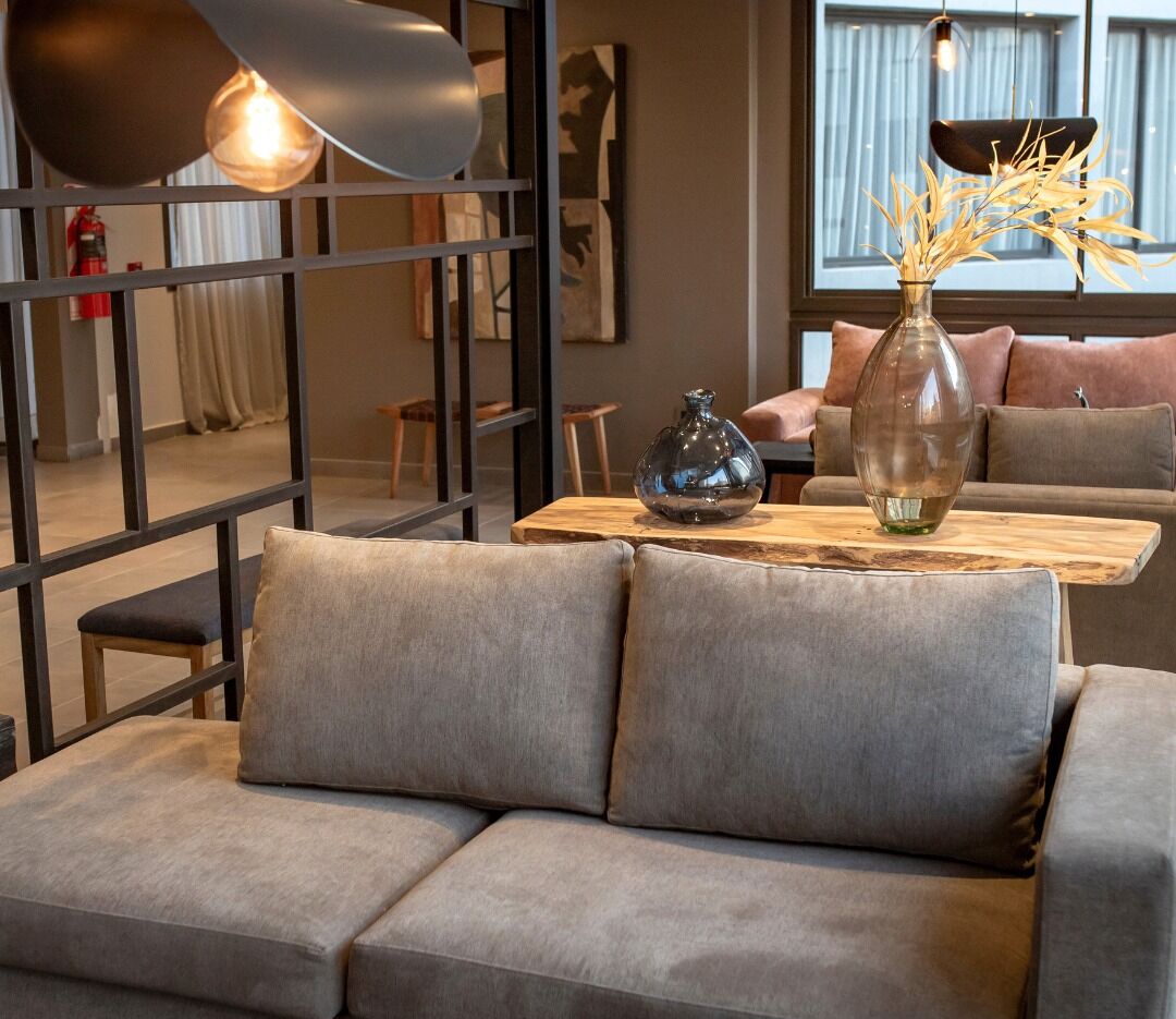 A modern living room with a grey sofa, a wooden coffee table, and decorative vases.