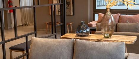 A modern living room with a grey sofa, a wooden coffee table, and decorative vases.