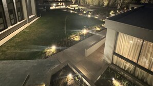 A modern building with a well-lit outdoor area featuring a landscaped garden and a swimming pool. - Amerian Chacras de Coria (Chacras de Coria)